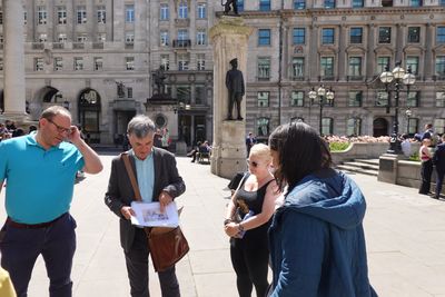 A guide shows colleagues an archive map of the City of London during a lunchtime walk