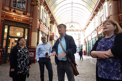 A guide talks to staff on their wellbeing day beneath the arcade of Leadenhall Market