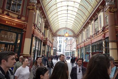 A group of City colleagues on a guided walk beneath the ornate painted roof of Leadenhall Market